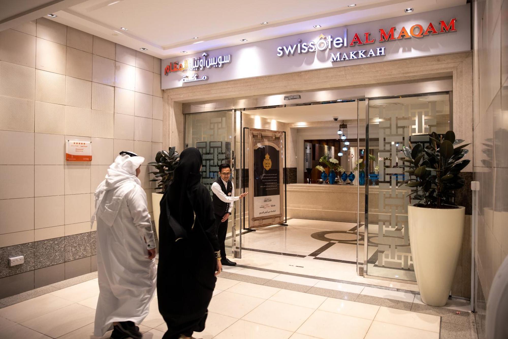 Swissotel Al Maqam Makkah Mekka Eksteriør billede The photo shows an entrance to the Swissôtel Al Maqam in Makkah, Saudi Arabia. The entrance is well-lit and features glass doors. There are two people approaching the entrance; one is dressed in traditional white clothing, while the other is in a bla